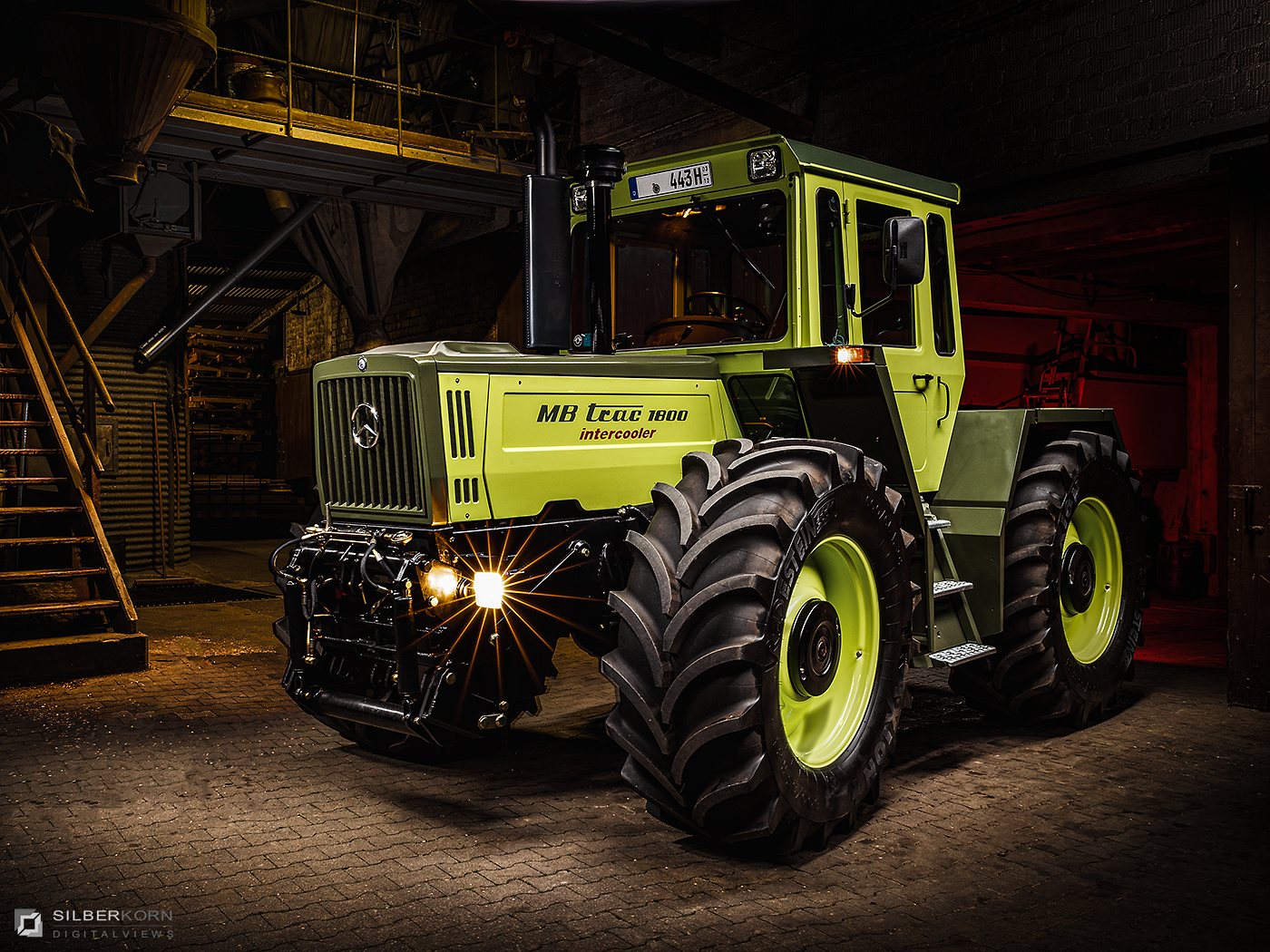 Grüner MB-trac 1800 bei Nacht in einer Industriehalle