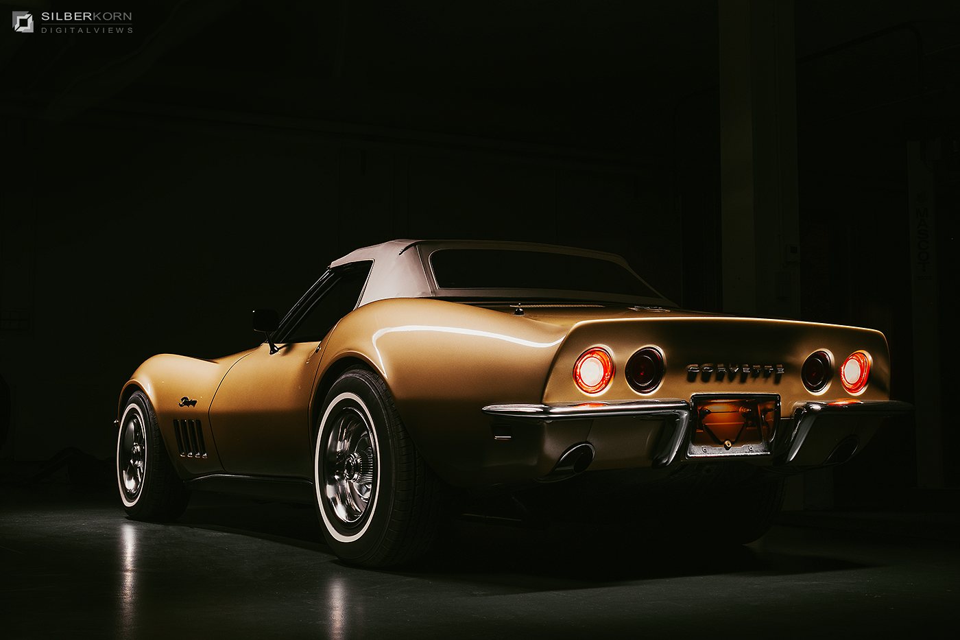 Goldene Corvette Stingray von hinten im Dunkeln